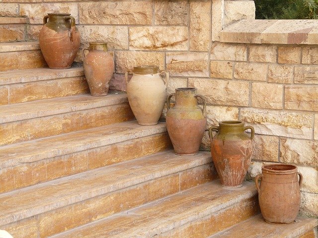Hnedé schody z kameňa a množstvo keramiky na nich.jpg