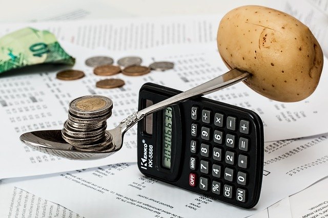 Lyžica na kalkulačke, na ktorej je zemiak a peniaze.jpg